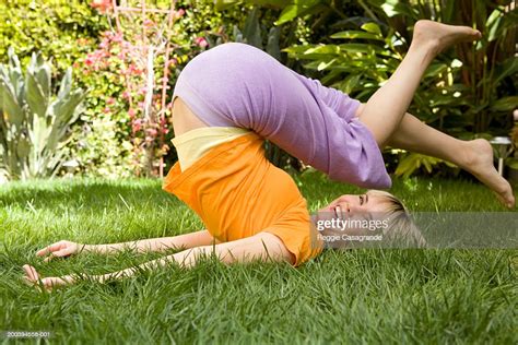 Young Woman Lying On Grass With Legs Above Head Smiling Foto De Stock Getty Images
