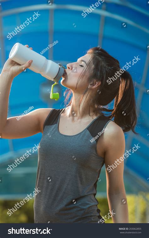 Fitness Beautiful Woman Drinking Water And Sweating After Exercising On