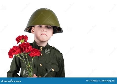 Sad Boy In Military Uniform And Iron Helmet Holds Flowers Isolated On