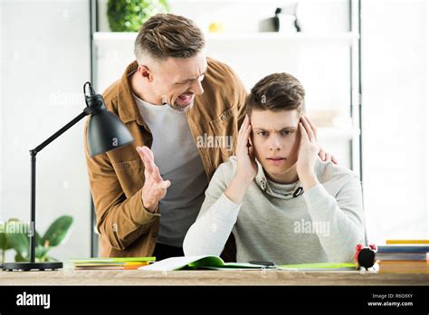 Angry Father Screaming At Teen Son Boy Covering Ears Stock Photo Alamy