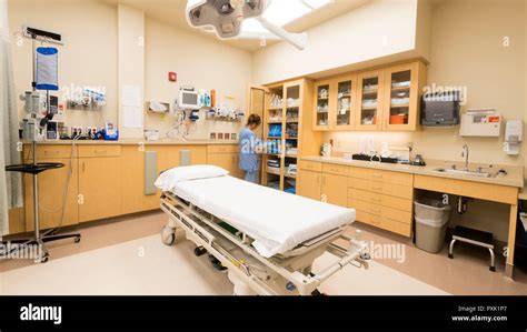 A Hospital Emergency Room Nurse Stocks A Cabinet With Trauma Supplies