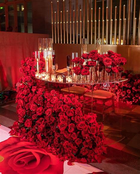Red Roses And Candles Are Arranged On A Table In The Middle Of A