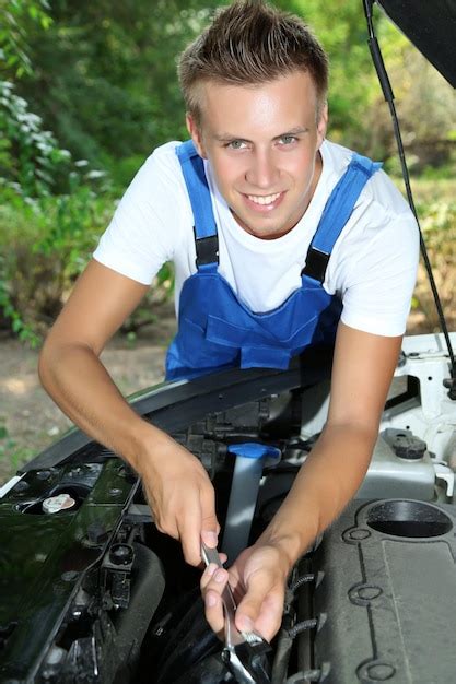 Premium Photo Young Car Mechanic Repairing Car Engine Outdoors