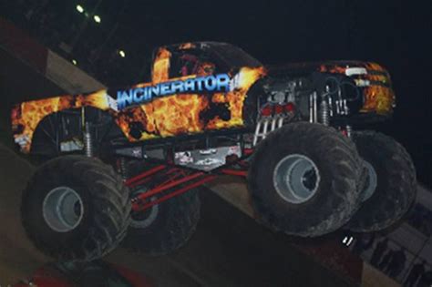 A Monster Truck With Flames On It Is In The Air