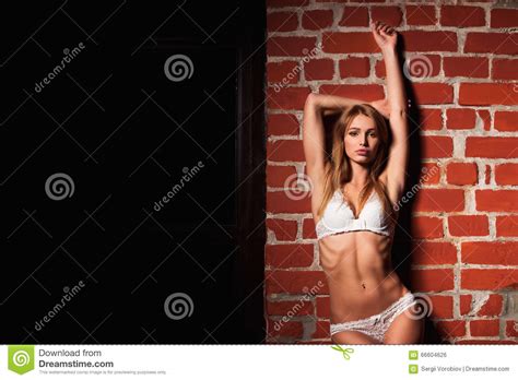 Sensual Pretty Woman In White Lingerie Close To Red Brick Wall
