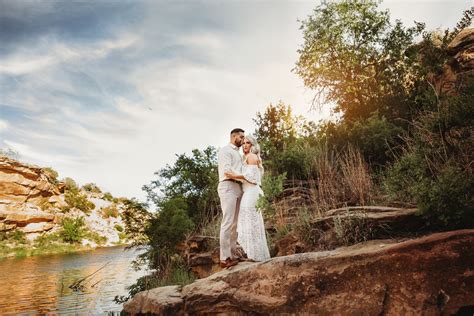 Standing On The River Bank In Casual White And Neutral Colored Casual Clothing Engagementphotos