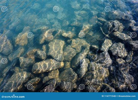 Stones With Gleams Of Sunshine Under Clear Water Stock Photo Image