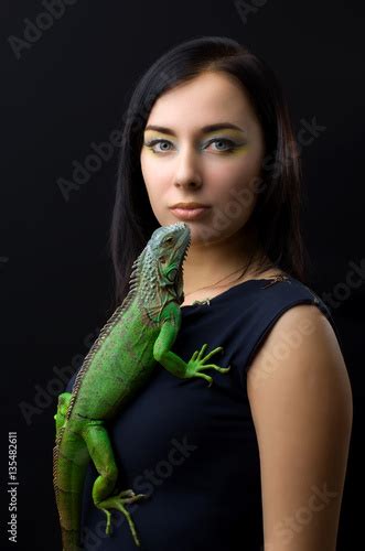 Beautiful Girl Portrait And Green Iguana In The Studio Stock Photo