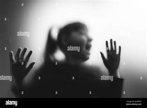 Scared, screaming girl behind the matte glass. Halloween festival