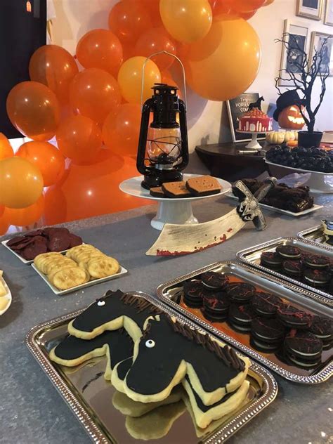 An Assortment Of Desserts On Trays At A Party With Balloons In The