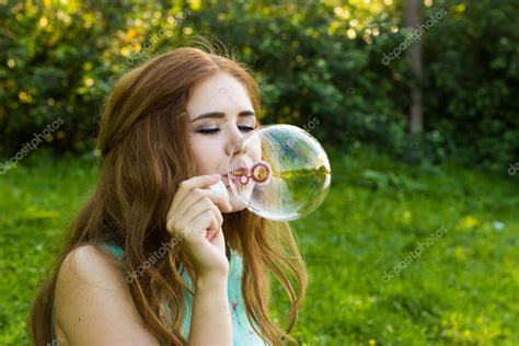 Beautiful Woman Blowing Bubbles In The Summer Near The Lake Outdoors