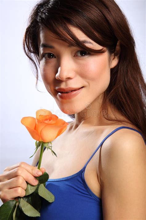 la muchacha japonesa joven hermosa con la naranja se levantó imagen de archivo imagen de