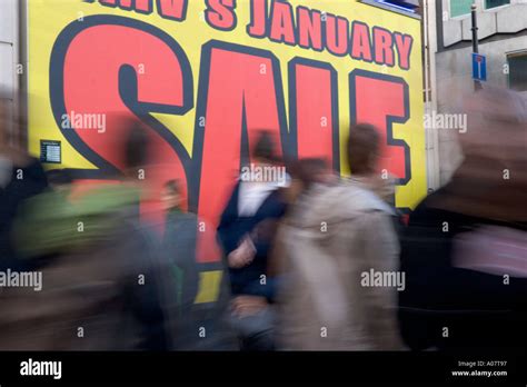 Bargain hunters shoppers walk past Sale signage in Oxford Street at