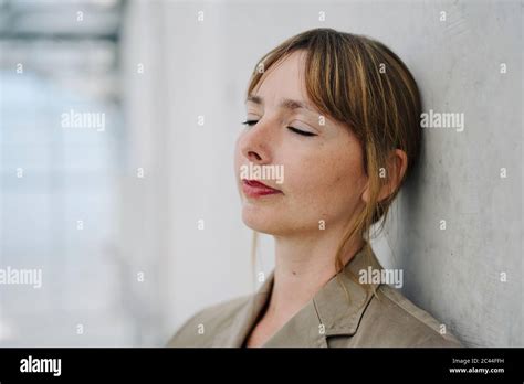 Portrait Of A Businesswoman With Closed Eyes Leaning Against A Concrete