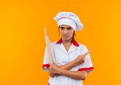 Zuversichtlich Junge Köchin Die Kochuniform Trägt Zeigt Auf Isolierte Gelbe Wand Mit