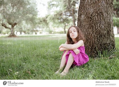 Kleines Mädchen Sitzt Unter Baum Im Park Ein Lizenzfreies Stock Foto