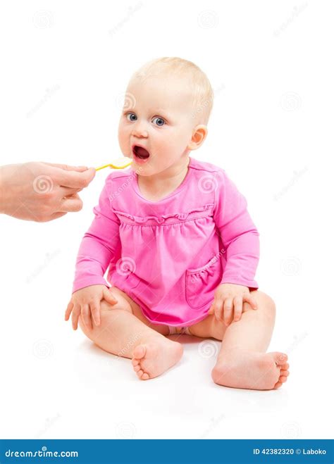 Sweet Baby Girl In Pink Dress Eats From Spoon Stock Photo Image Of