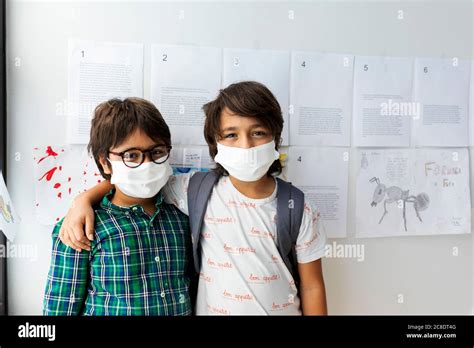 Friends Wearing Masks Standing Against Wall In School Stock Photo Alamy
