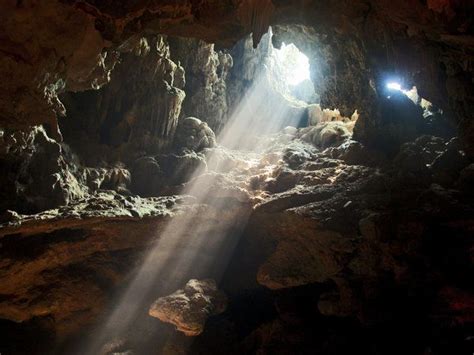 The Light Shines Brightly Through An Opening In A Cave