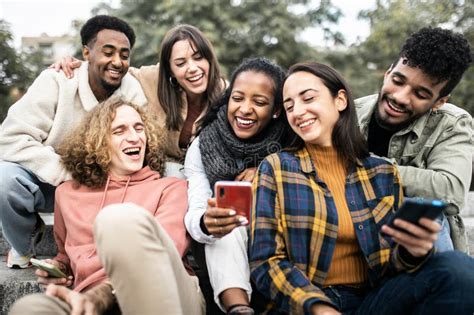 Happy Group Of Young People Having Fun Using Smartphone Outdoors Stock