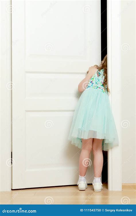 A Little Girl Is Standing By The Door Stock Photo Image Of Cute