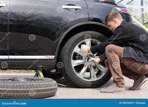 Man Changing His Spare Wheel Stock Photo Image Of Assistance Bending