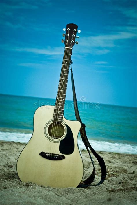 Guitar On The Beach A Guitar Left Standing On A Beach With The Gentle