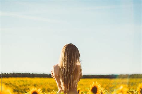 Nude Woman Is Looking At Sunflowers By Stocksy Contributor Javier