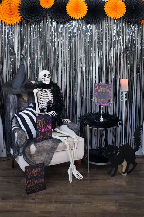 A Skeleton Sitting On A Couch In Front Of A Party Backdrop With Black