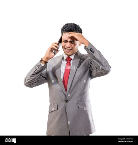Stressed Young Man Wearing Suit Hold His Head While Making A Phone