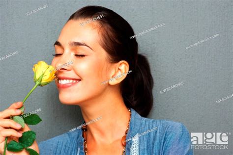 Pretty Woman Smelling Yellow Rose With Eyes Closed Stock Photo