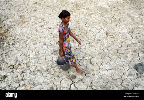 Allahabad India 3rd May 2016 An Indian Girl Walks On Craked Bed Of A Dried Water Pond As She
