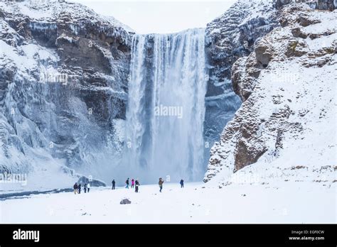 Tourists Visiting Skogafoss Waterfall In Winter Skogar South Iceland