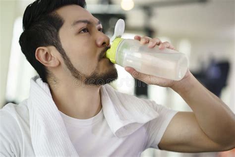 Asian Man Drinking Water From Bottle After Exercise In Fitness G Stock