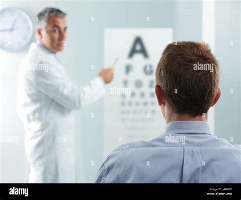 Optometrist And Patient Doctor Pointing At Eye Chart Stock Photo Alamy