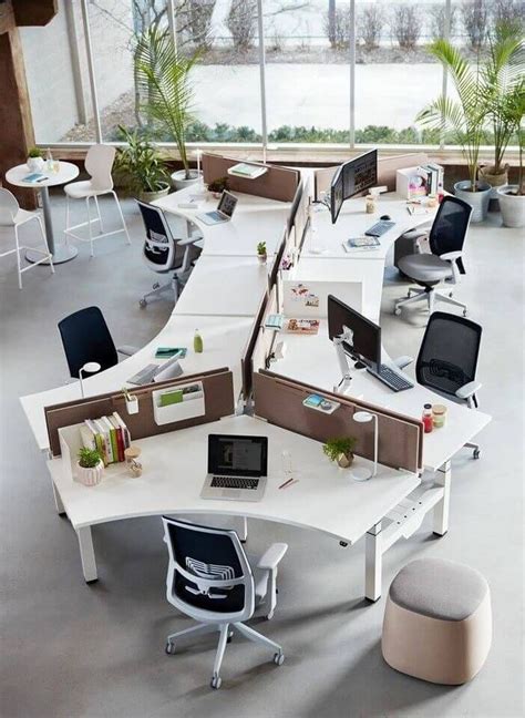 An Office Cubicle With Multiple Desks And Chairs In The Center Along