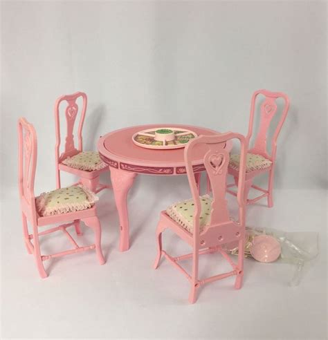A Doll House Table And Chairs With Plates On The Plate In The Center