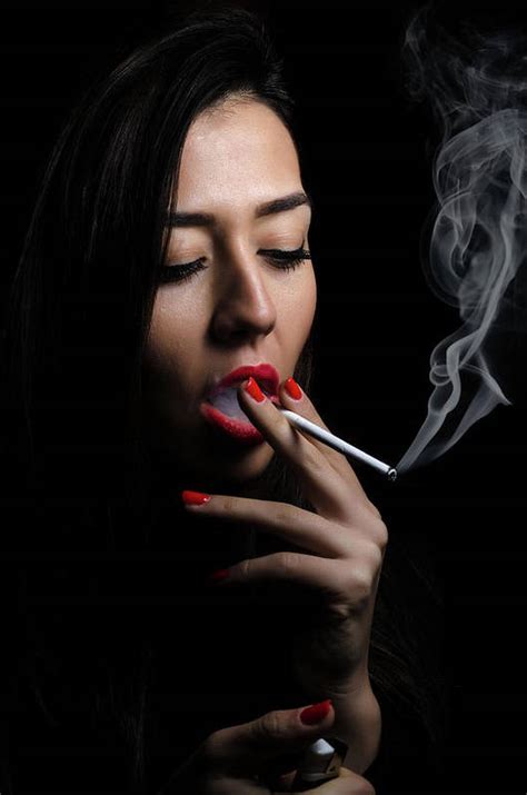 Portrait Of The Beautiful Elegant Girl Smoking Cigarette On Black