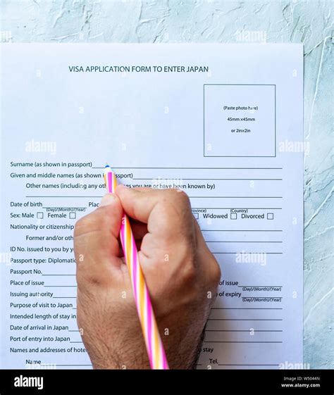 The Person Filling The Visa Application Form To Enter Japan Stock Photo