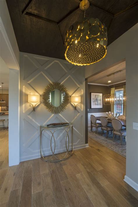 Entry spaces are magnets for clutter, however, it can be difficult to decorate a space. A geometric accent wall, gold starburst mirror and large ...