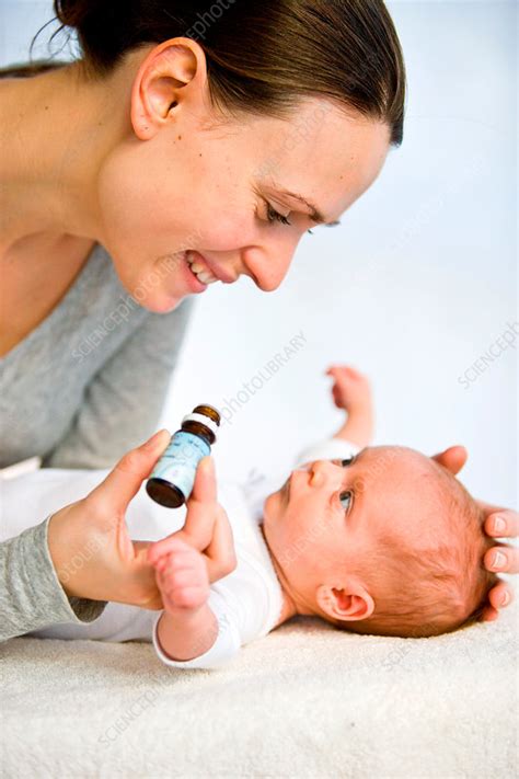 And are babies with dark skin at higher risk of rickets? Mother giving vitamin D to baby - Stock Image - C031/3005 ...