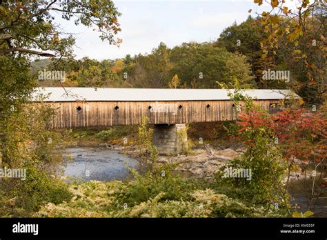 Fall Foliage On Tree Lined Banks Of River With Oldest Covered Wooden