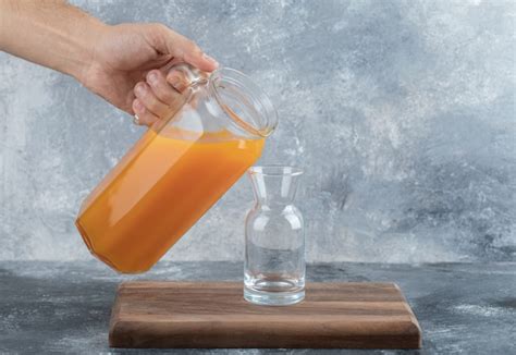 Free Photo Male Hand Pouring Orange Juice Into Glass
