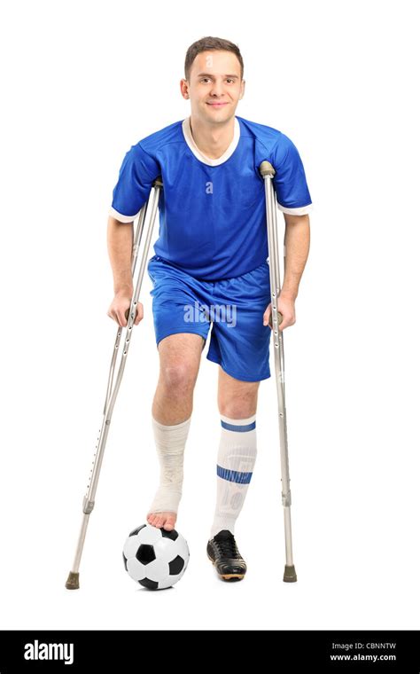 Full Length Portrait Of An Injured Soccer Football Player On Crutches