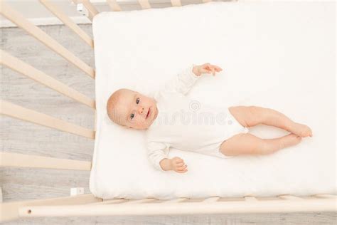 Sleeping Baby And His Toy In White Crib Nursery Interior And Bedding