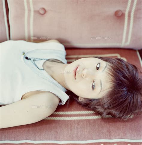 ソファーに寝転ぶ仰向けの日本人女性 02299002360 の写真素材イラスト素材アマナイメージズ