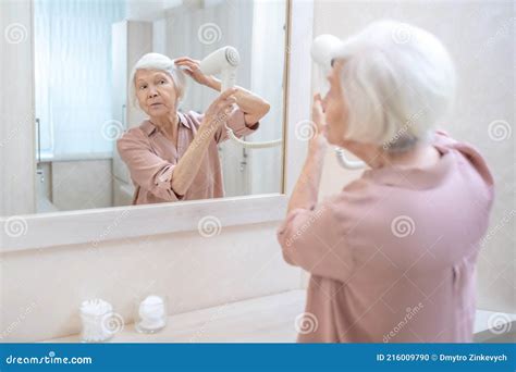 Gray Haired Mature Woman Drying Her Hair In A Changing Room In Spa