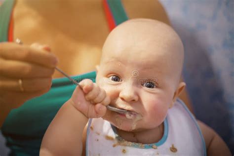 Funny And Cute Baby Eats First Meal In A Spoon A Newborn Boy Is