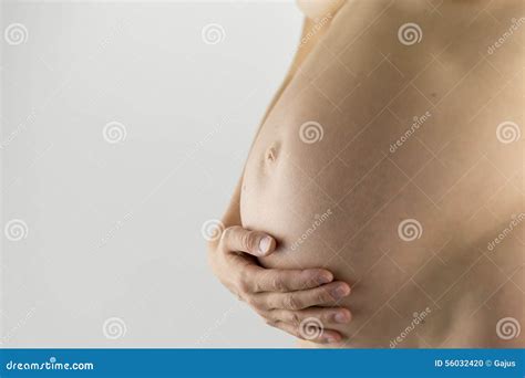 Bare Swollen Belly Of A Pregnant Woman Cupped By Her Hands Royalty Free