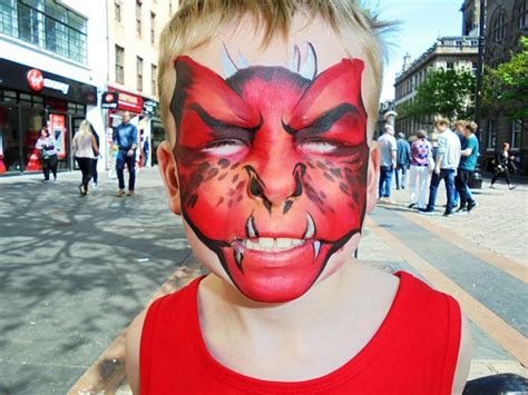 Premium Photo Close Up Of Boy With Red Face Paint On Street
